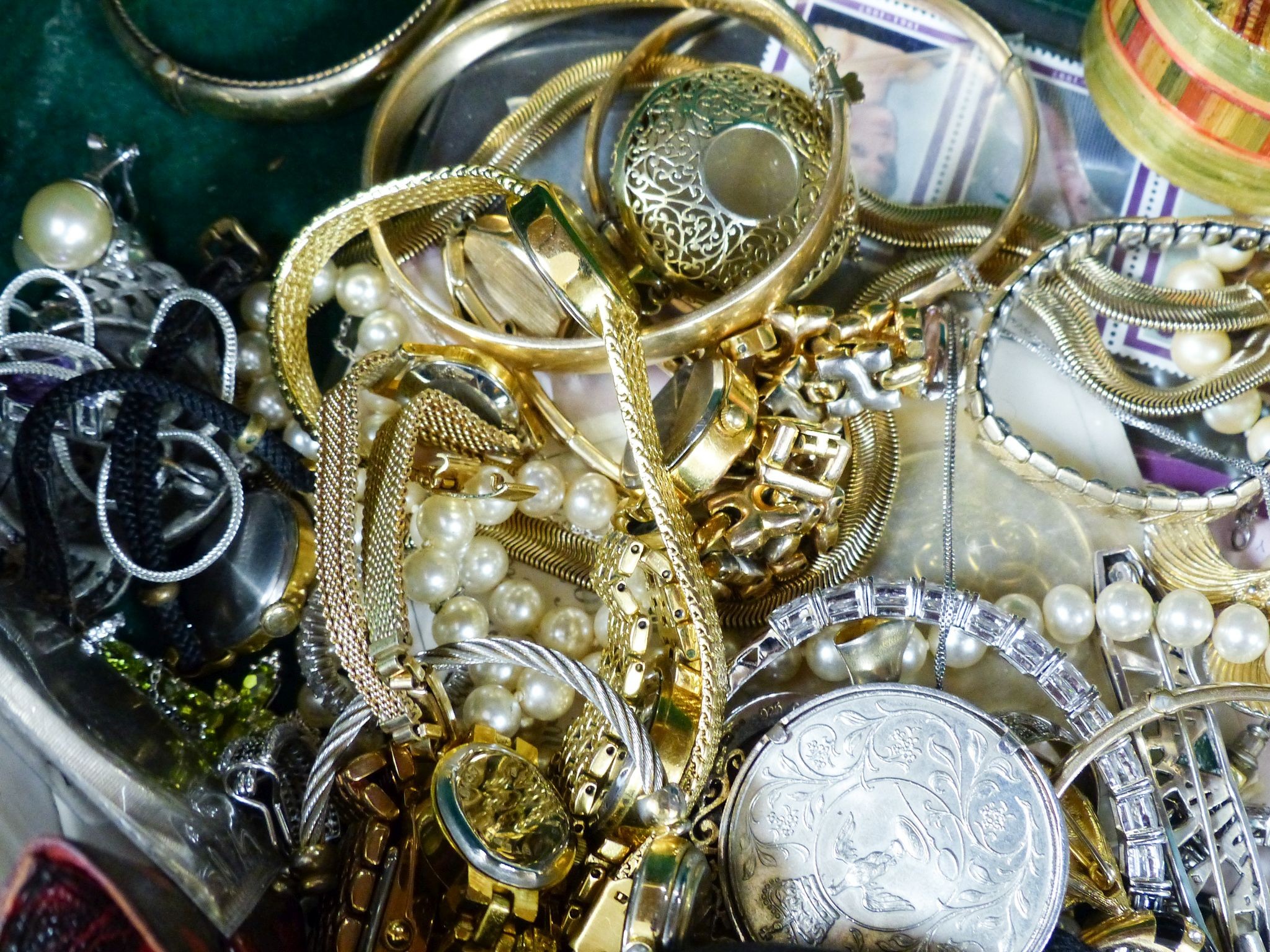 A quantity of assorted costume jewellery and coins etc. in a walnut box.